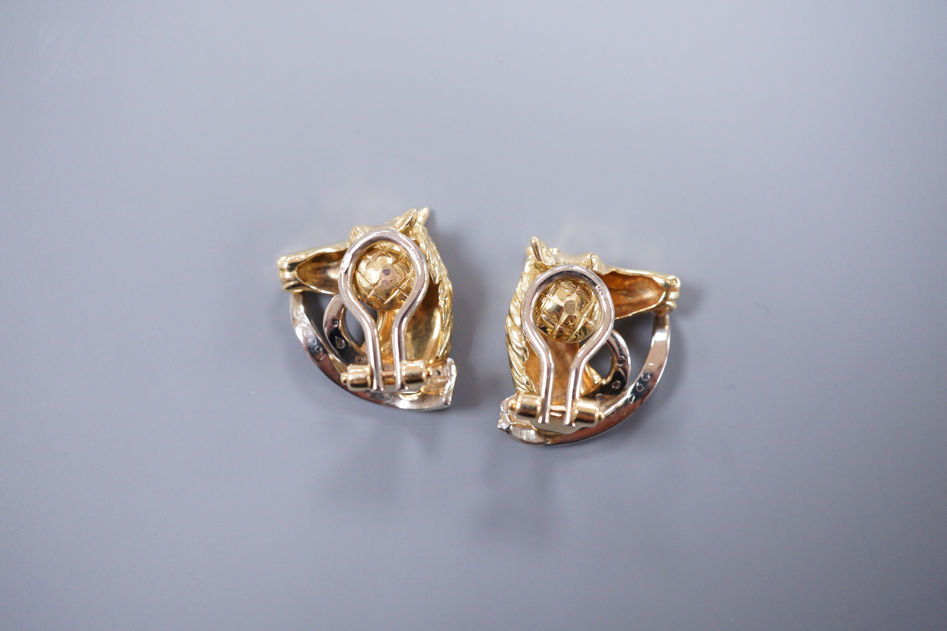 A pair of diamond set 18ct gold horse head ear clips, 2cm, gross 9.8 grams